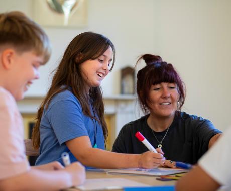 Child and teacher at a desk looking at work