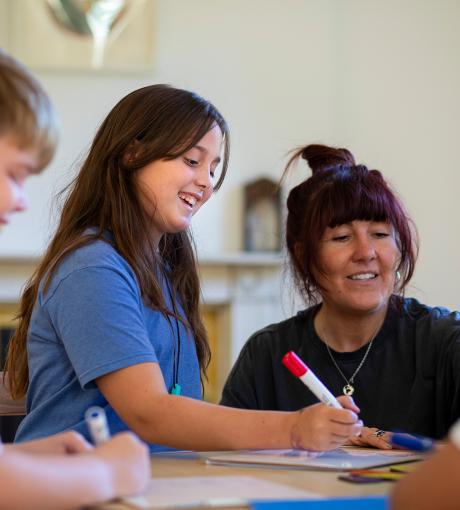 Child and teacher at a desk looking at work