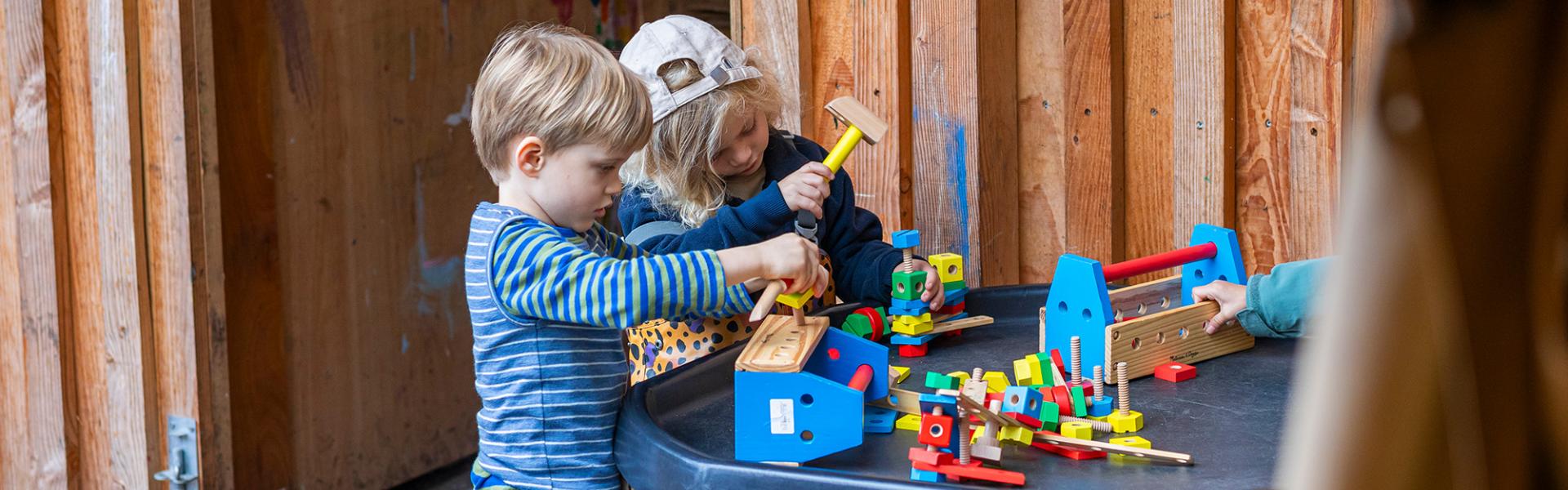 2 children playing with building blocks